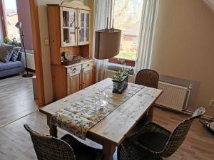 a wooden table with chairs in a living room at Ferienwohnung Ostsee in Karby