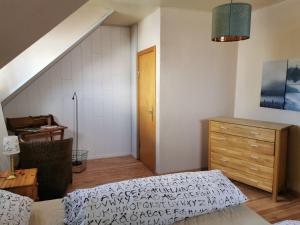 a bedroom with a bed and a dresser and a staircase at Ferienwohnung Ostsee in Karby