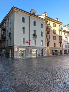 a large white building on a cobblestone street at Maison Boch in Aosta
