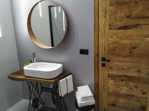 La salle de bains est pourvue d'un lavabo et d'un miroir. dans l'établissement Maison Boch, à Aoste