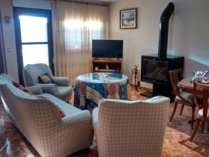 a living room with a table and chairs and a fireplace at Casa La Huerta in Bubión