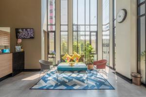 a lobby with a table and chairs and a clock at Casaluxe Hotel and Resident in Bangkok
