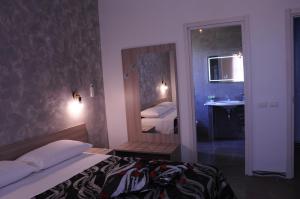 a bedroom with a bed and a sink and a mirror at La Fenice in Lampedusa