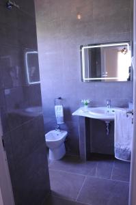 a bathroom with a sink and a toilet and a mirror at La Fenice in Lampedusa