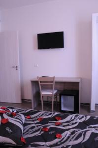 a bedroom with a bed and a desk and a television at La Fenice in Lampedusa