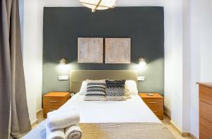 una camera da letto con un grande letto bianco con due lampade di Apartamento Fuente Olleta a Málaga