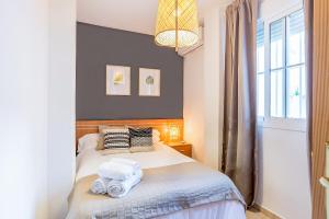 1 dormitorio con 1 cama con toallas en Apartamento Fuente Olleta, en Málaga