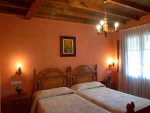 PiloñaにあるTurismo Rural el Sidronのベッドルーム1室(ベッド2台、シャンデリア付)