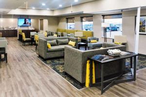 a waiting room with couches and tables and chairs at Comfort Inn & Suites Conway in Conway