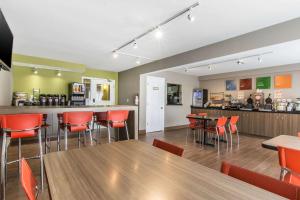 a restaurant with tables and chairs and a bar at Comfort Inn Magnetic Hill in Moncton