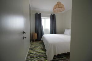 um quarto com uma cama, uma janela e uma porta em Coastal View Flat - amazing views over the Atlantic em Viana do Castelo