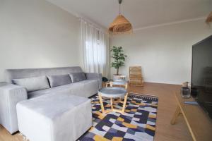 a living room with a couch and a table at Coastal View Flat - amazing views over the Atlantic in Viana do Castelo