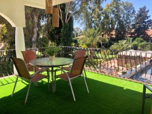 a table and chairs on a lawn with grass at PUERTO BANUS POL One in Marbella