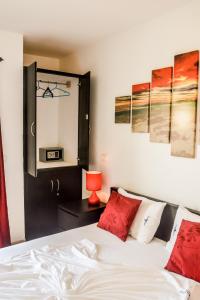 a bedroom with a bed with red pillows and a mirror at Leme Bedje Residence in Santa Maria