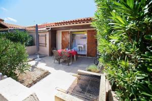 a patio with a table and chairs in a backyard at le soleil bleu wifi clim in Le Barcarès +34 photos