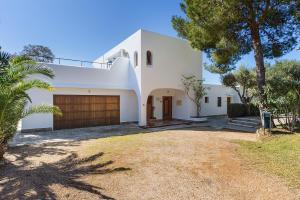 ein weißes Haus mit großer Garage in der Unterkunft Apartamentos Cala Murada Tennis in Cala Murada