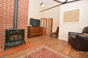 a living room with a brick wall and a fireplace at wingate cottage in Southburgh