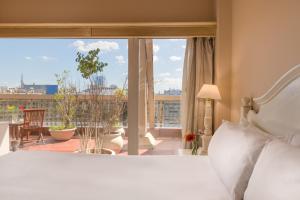 sypialnia z łóżkiem i dużym oknem w obiekcie Exe Hotel Colón w BuenosAires