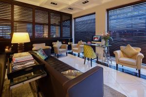 a living room with a couch and chairs and windows at Boutique Hotel Notting Hill in Amsterdam