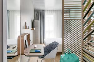 a room with a desk with a computer and a staircase at OKKO Hotels Toulon Centre in Toulon