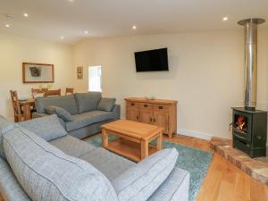 a living room with two couches and a stove at Y Felin - Celyn in Borth