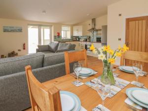 a dining room and living room with a table and a couch at Y Felin - Celyn in Borth