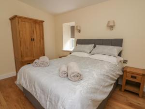 a bedroom with a bed with towels on it at Y Felin - Celyn in Borth