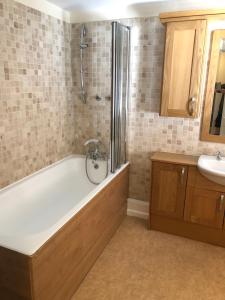 a bathroom with a bath tub and a sink at Byways Serviced Apartments in Salisbury +41 photos