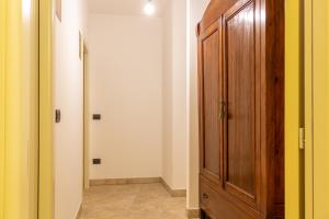 a hallway with a wooden cabinet and a door at La Merlana affittacamere in Morrovalle