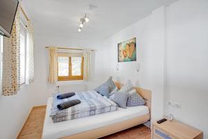ein weißes Zimmer mit einem Bett und einem Fenster in der Unterkunft Almrausch Ferienwohnung in Ramsau bei Berchtesgaden