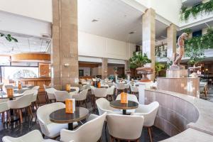 un ristorante con tavoli e sedie in un edificio di Louis Phaethon Beach a Paphos