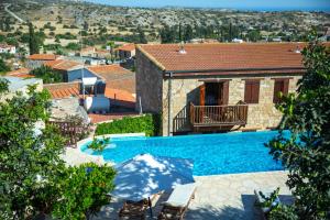 a villa with a swimming pool and a house at Eveleos Country House in Tochni