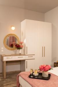 una camera da letto bianca con tavolo e specchio di Sunrise Resort Hotel a Mythimna