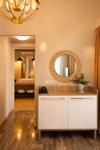 ein Bad mit einem weißen Waschtisch und einem Spiegel in der Unterkunft Sunrise Resort Hotel in Mythimna