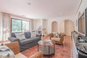 een woonkamer met een bank en een tafel bij Excellent T2 apartment with pools 400m Falesia beach in Albufeira