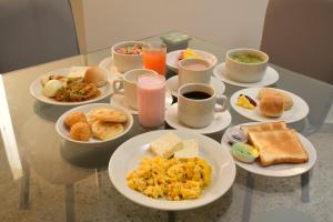 a table topped with plates of breakfast foods and drinks at Hotel Arawak Upar in Valledupar
