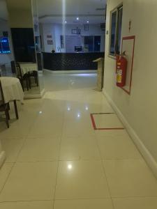 suelo de baldosa blanca en un restaurante con extintor de incendios en PEDRA BONITA PRECIOSO HOTEL ltda, en Itaboraí