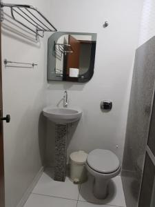 a bathroom with a sink and a toilet and a mirror at PEDRA BONITA PRECIOSO HOTEL ltda in Itaboraí