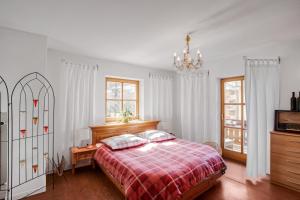 een slaapkamer met een bed en een kroonluchter bij Ferienwohnung Edelweiß in Schönau am Königssee