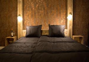 ein Schlafzimmer mit einem großen Bett mit zwei Kissen in der Unterkunft Puurderij B&B en meer... in Nijeveen