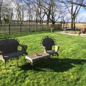 two chairs and a table in the grass at wingate cottage in Southburgh