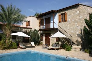 a villa with a swimming pool and a house at Porfyrios Country House in Chirokitia