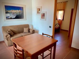 a living room with a table and a couch at Residence La Luna Nel Pozzo in Sciacca