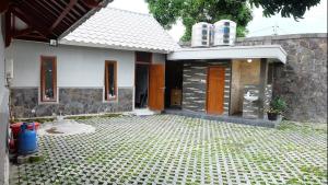 una casa con un cortile piastrellato di fronte di Omah Dronjongan Homestay Yogyakarta a Yogyakarta