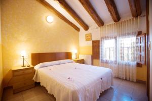 Un dormitorio con una cama blanca y una ventana. en Hostal Las Rumbas, en Nuévalos