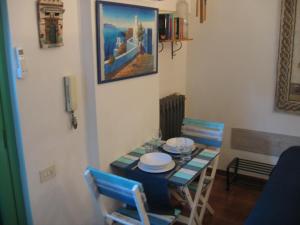 una sala da pranzo con tavolo, sedie e un dipinto di Appartamento Vivaldi a Mondello