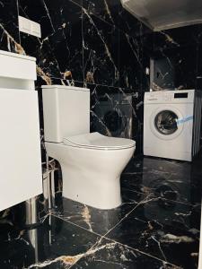 a bathroom with a toilet and a washing machine at Acrotel Porto Brava Luxury Villas in Ormos Panagias