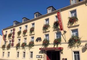un gran edificio blanco con cajas de flores. en Hotel Schwarzer Bär, en Zittau