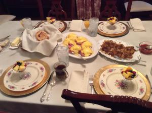 une table avec des assiettes de nourriture au-dessus dans l'établissement Adair Manor Bed & Breakfast, à Adairsville