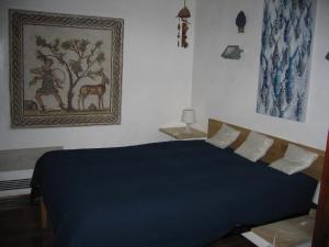 una camera con un letto blu e un dipinto sul muro di Appartamento Vivaldi a Mondello